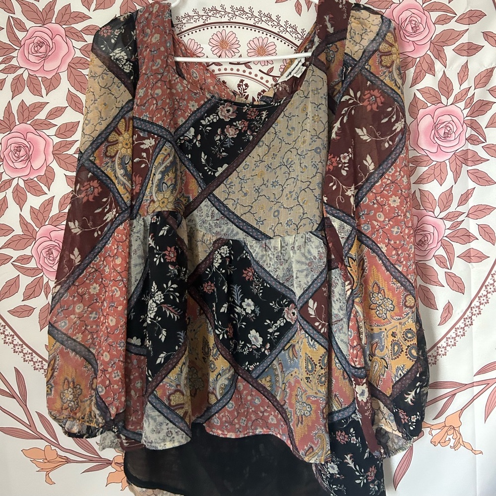 A size medium blouse. Has different colors and patterns with a neutral colors.